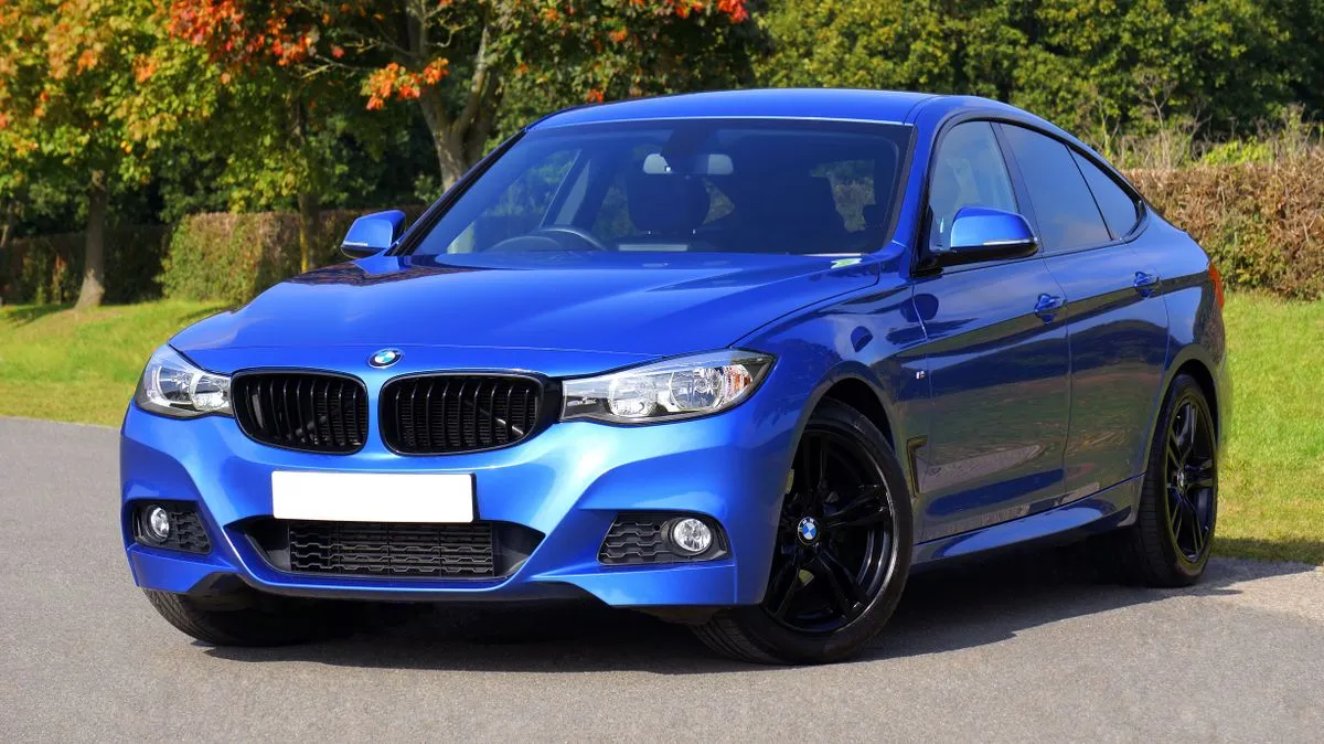 Premium blue sedan parked near greenery