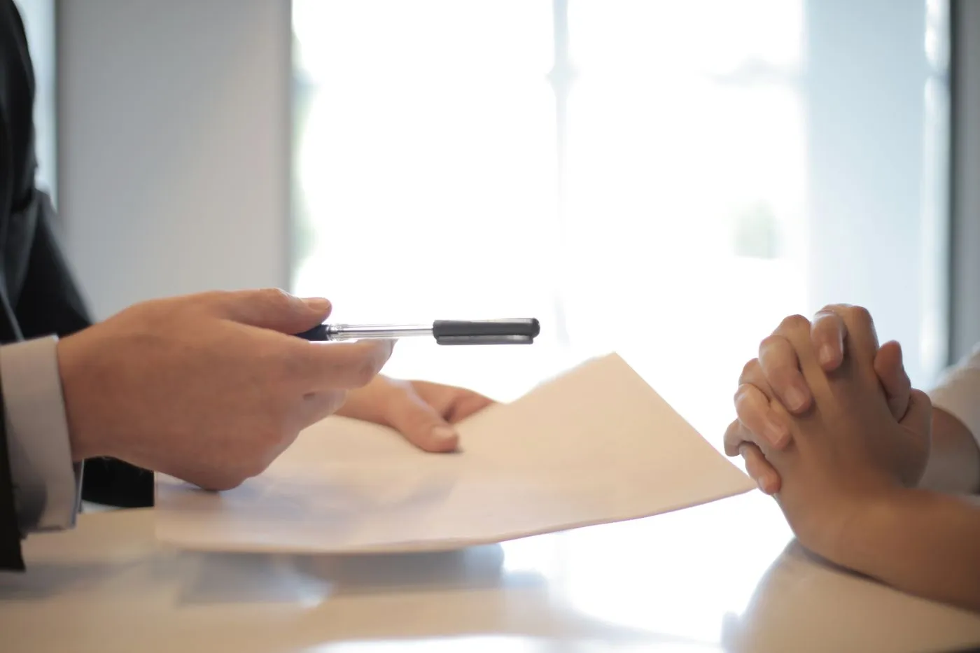 Documents being handed over across a desk