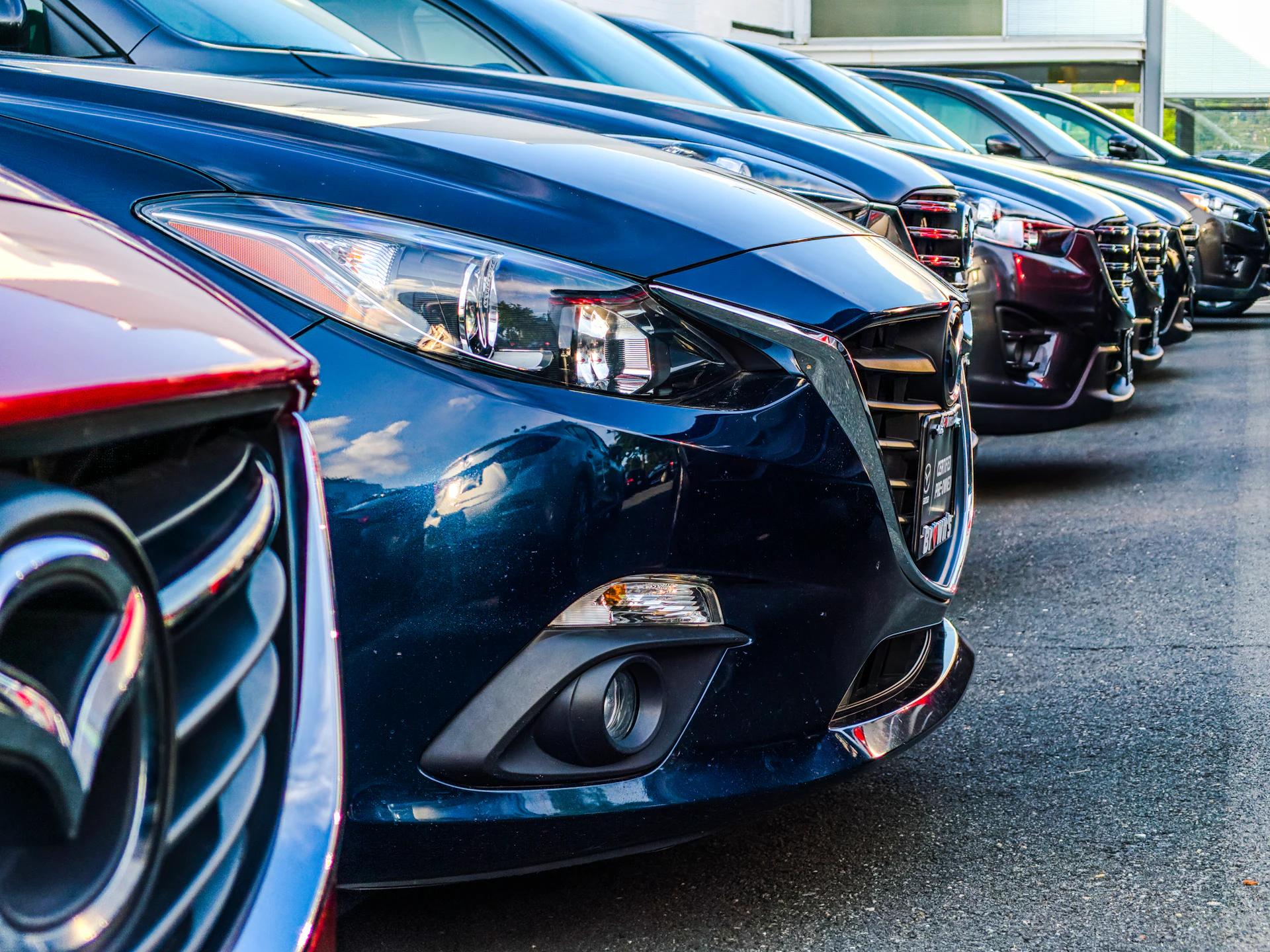 Row of pre-owned cars parked outside a dealership