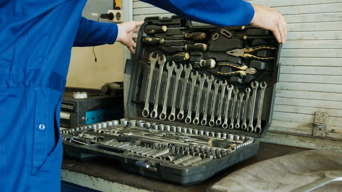 Technician holding a full socket tool set in the workshop